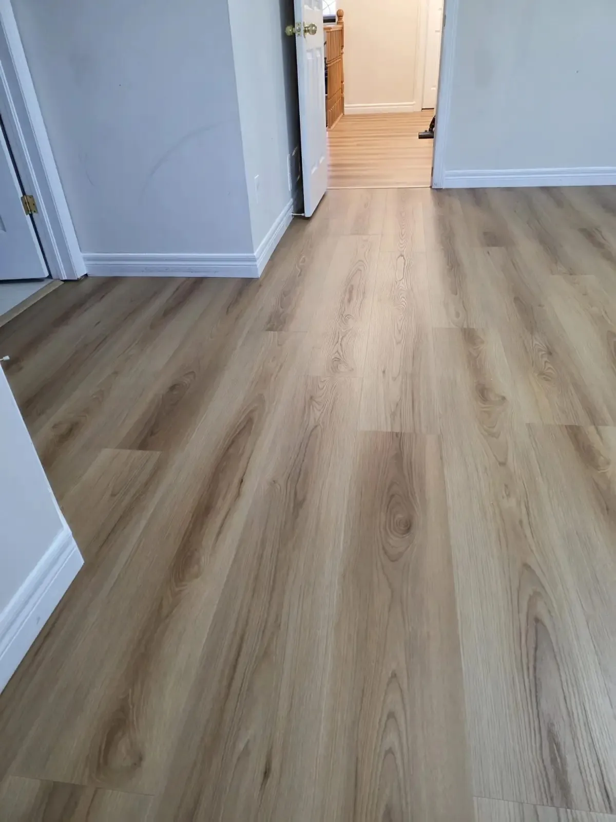 Luxury vinyl plank flooring in a hallway with warm oak tones