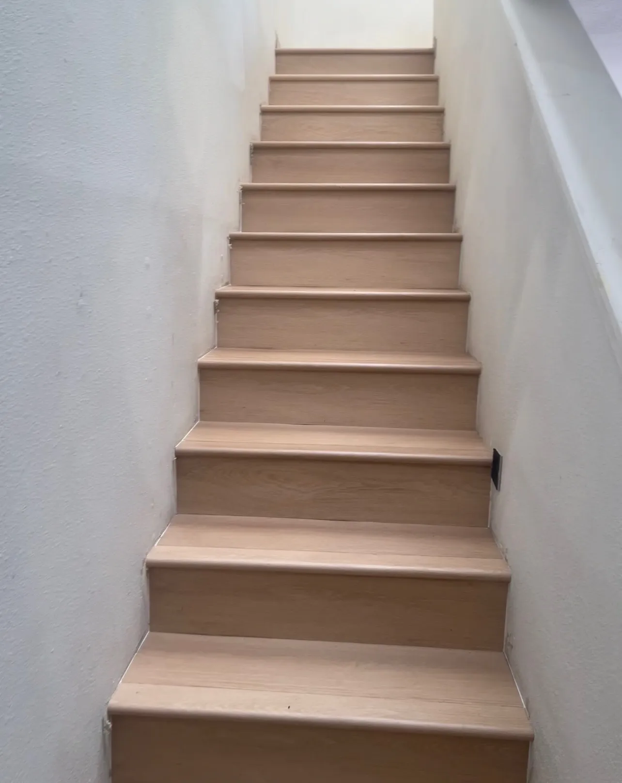 Luxury vinyl plank installed on stairs with matching treads and risers