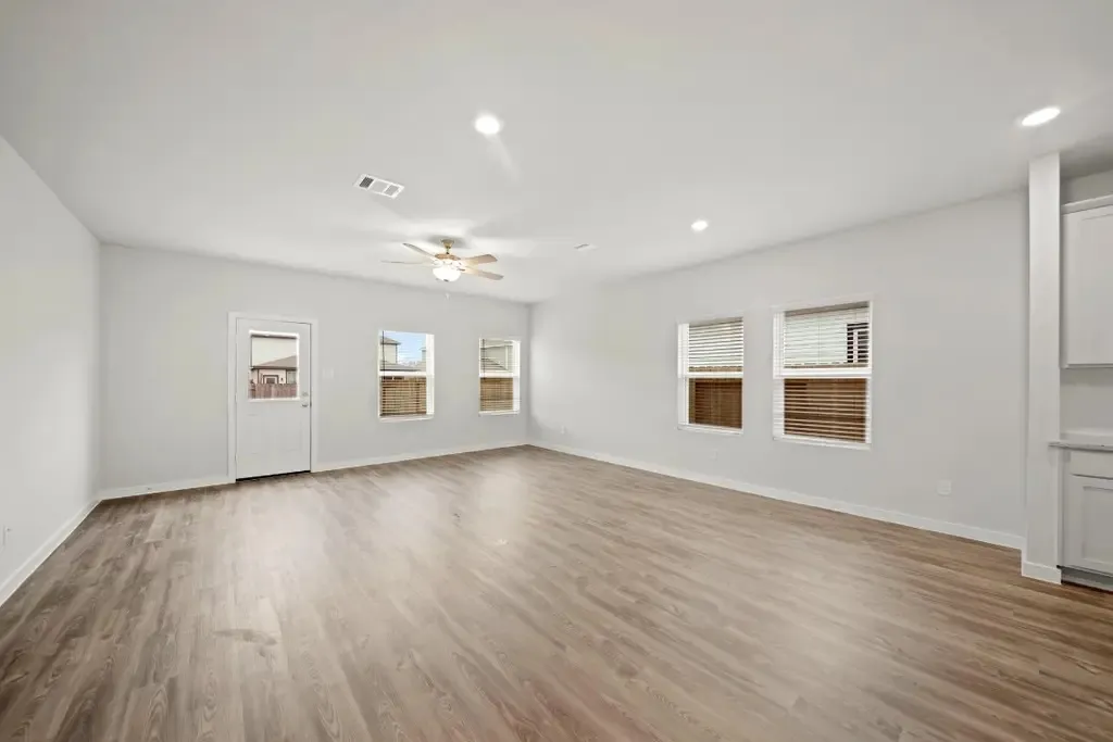 Luxury vinyl plank in an open living room with warm brown tones and ceiling fan