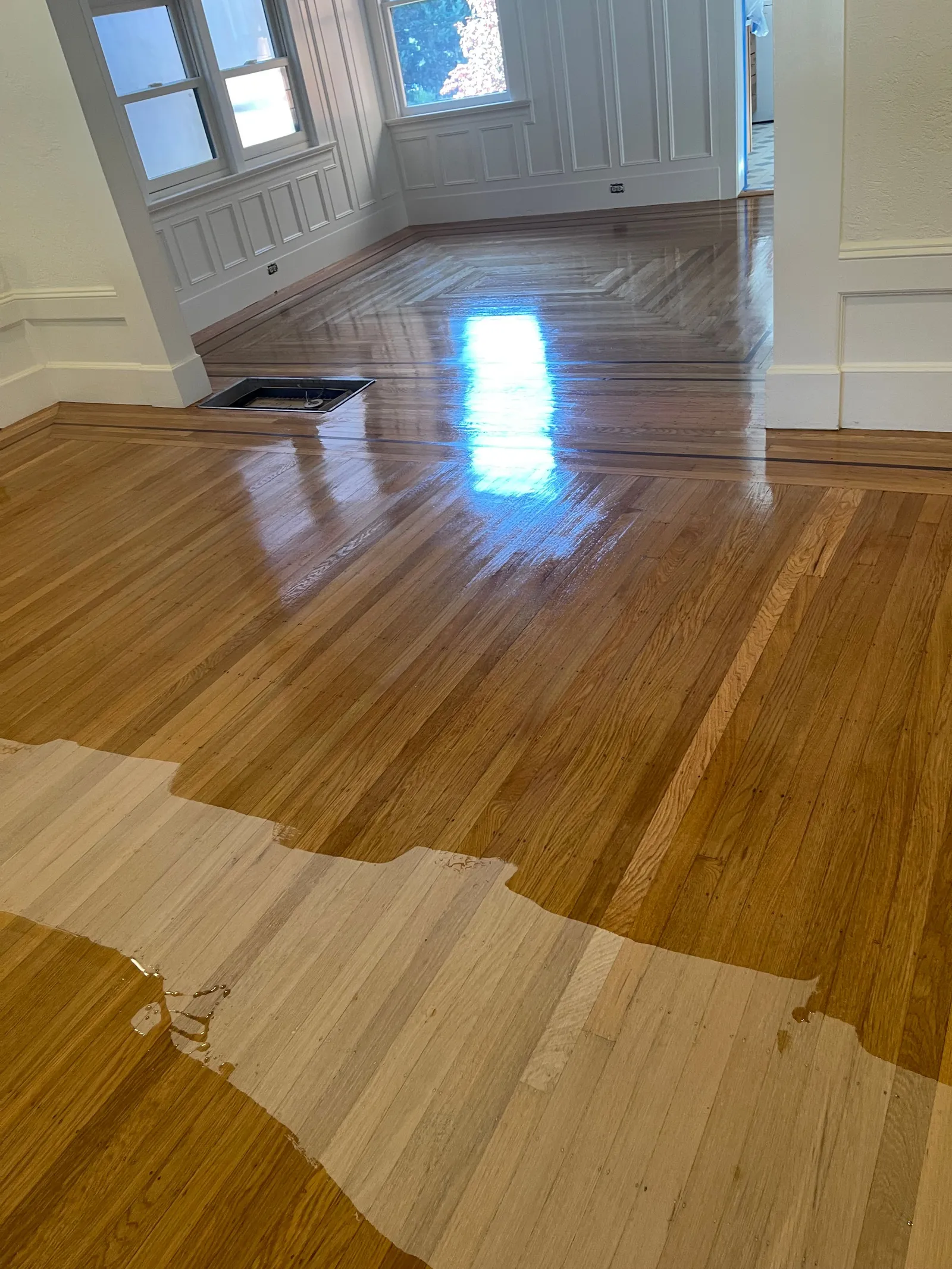 Hardwood floor refinishing in progress showing stain application