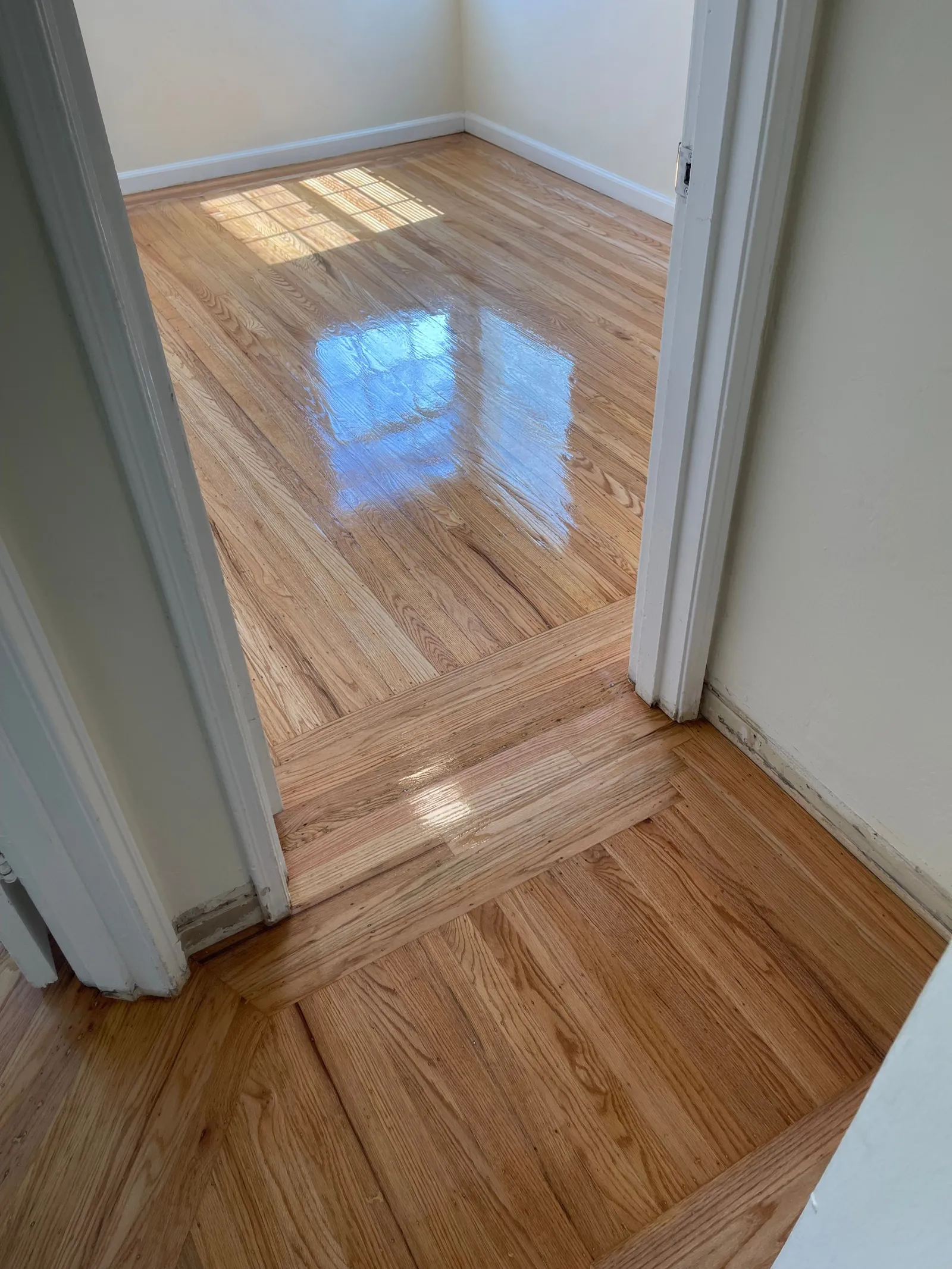 Refinished natural oak hardwood floor through a doorway in a classic home